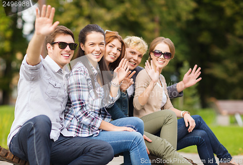 Image of group of students or teenagers waving hands