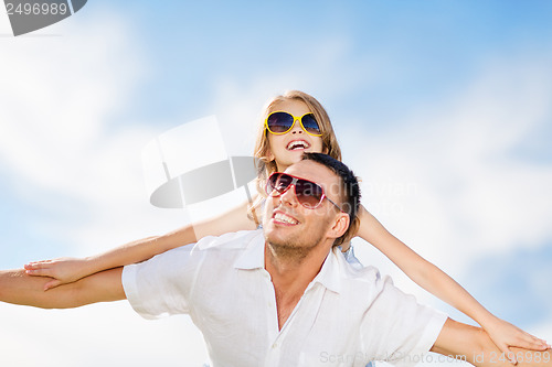 Image of happy father and child in sunglasses over blue sky
