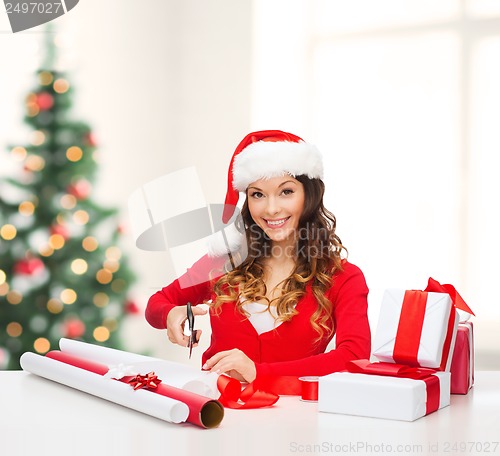 Image of smiling woman in santa helper hat with gift box