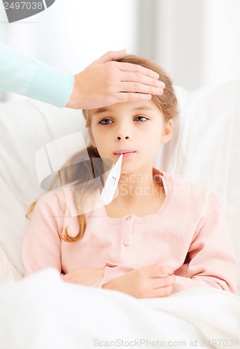 Image of ill girl child with thermometer and caring mother