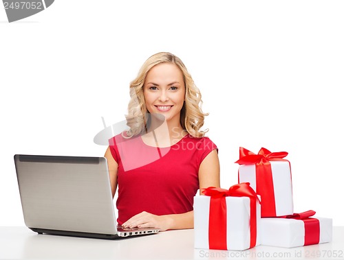 Image of woman with gift boxes and laptop computer