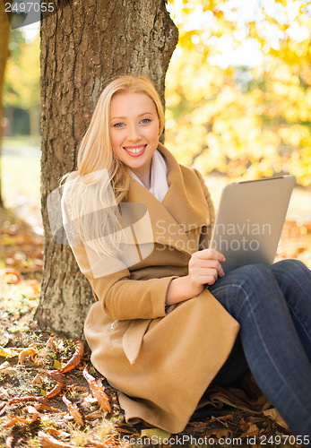 Image of woman with tablet pc in autumn park