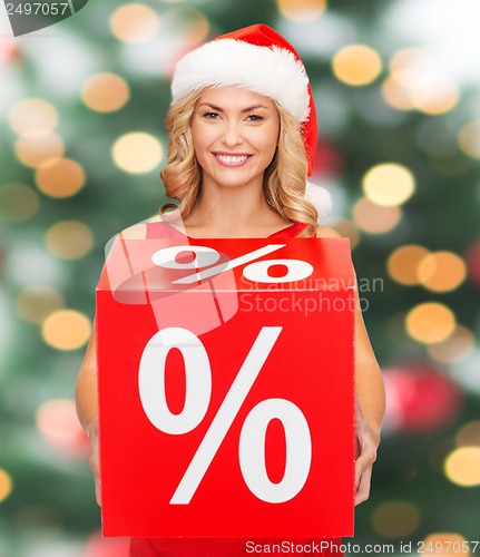 Image of woman in santa helper hat with red sale sign