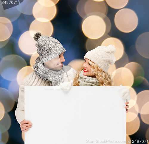 Image of couple in winter clothes with blank white board