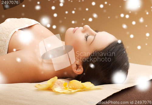 Image of woman in spa salon lying on the massage desk