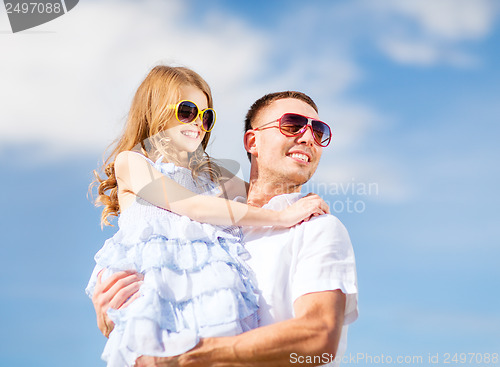 Image of happy father and child in sunglasses over blue sky