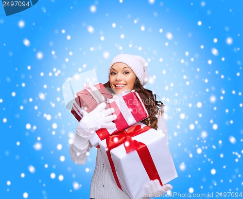 Image of woman in sweater and hat with many gift boxes