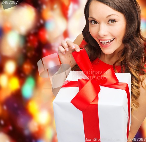 Image of smiling woman in red dress with gift box