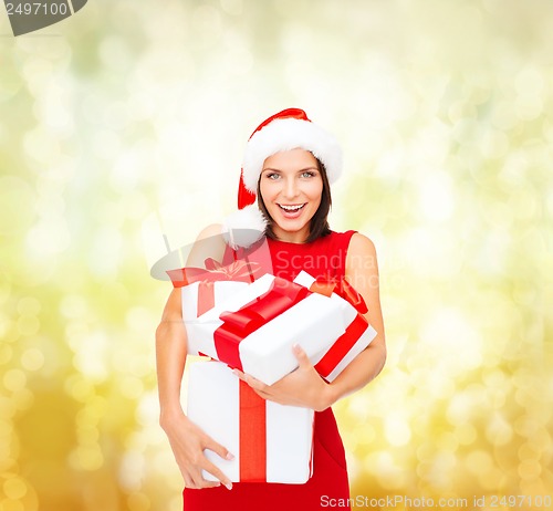 Image of woman in santa helper hat with many gift boxes