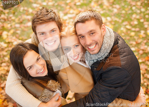 Image of group of friends having fun in autumn park