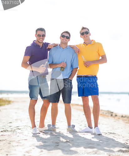 Image of friends on the beach with bottles of drink