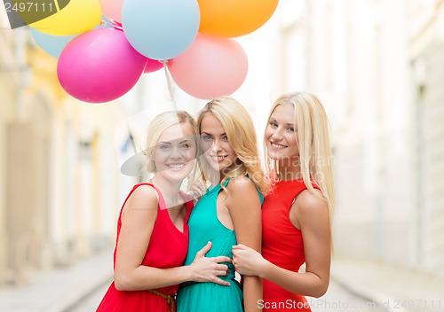 Image of beautiful girls with colorful balloons in the city