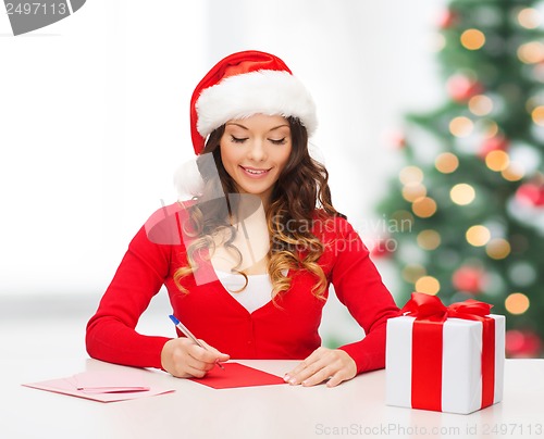 Image of smiling woman in santa helper hat with postcard