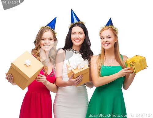 Image of three smiling women in blue hats with gift boxes