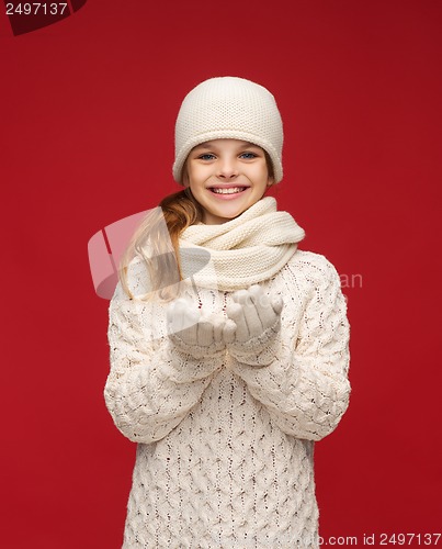 Image of girl in winter clothes with something on palms