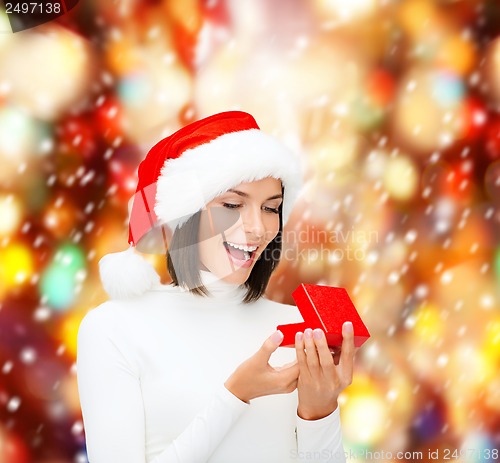 Image of surprised woman in santa helper hat with gift box