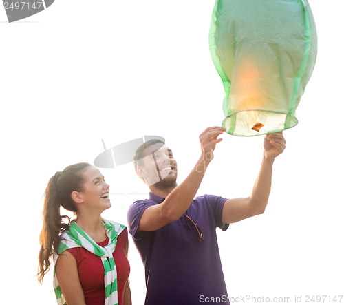 Image of couple with chinese sky lanterns on the beach