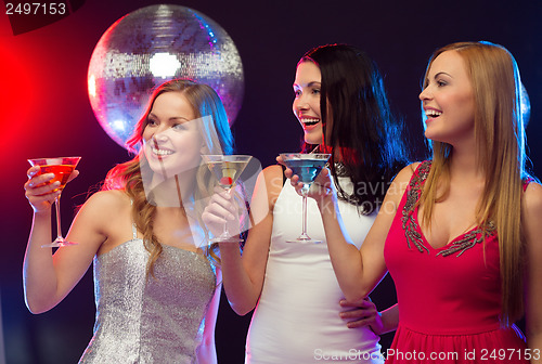 Image of three smiling women with cocktails and disco ball