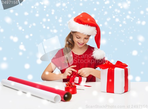 Image of smiling girl in santa helper hat with gift box