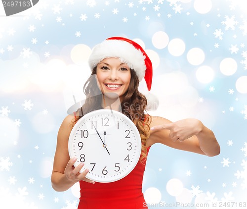 Image of woman in santa helper hat with clock showing 12