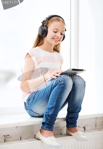 Image of girl with tablet pc and headphones at home