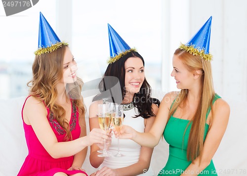 Image of three women wearing hats with champagne glasses