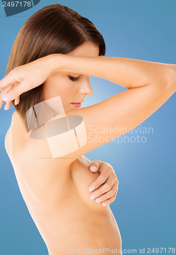 Image of woman checking breast for signs of cancer