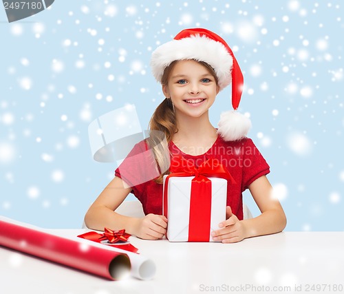 Image of smiling girl in santa helper hat with gift box