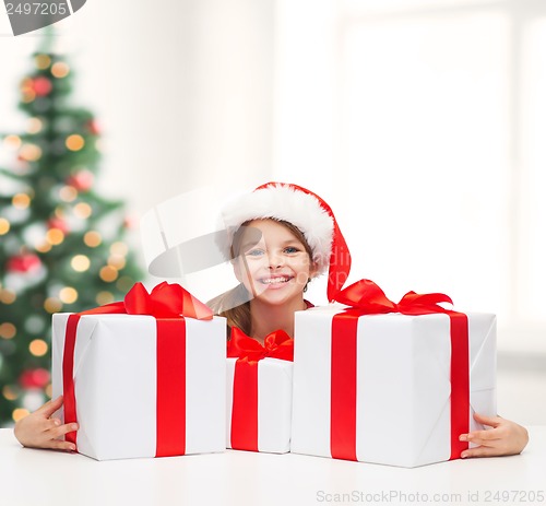 Image of girl in santa helper hat with many gift boxes