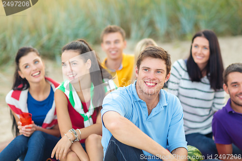 Image of group of friends looking up on the beach