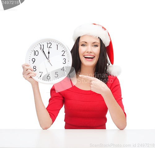 Image of woman in santa helper hat with clock showing 12