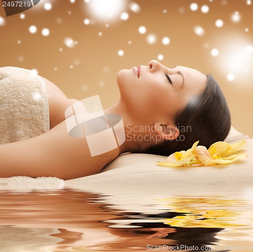 Image of woman in spa salon lying on the massage desk