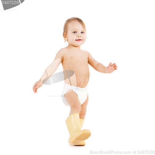 Image of cute little boy walking in big rubber boots