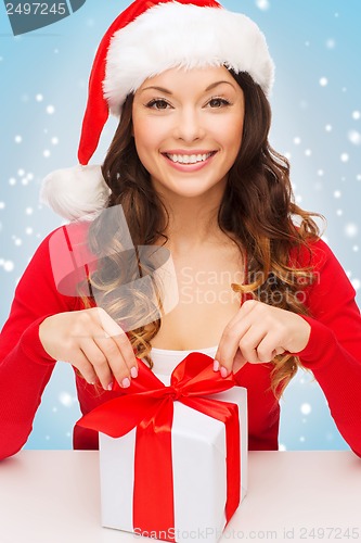 Image of smiling woman in santa helper hat with gift box