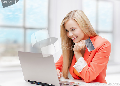 Image of happy teenage girl with laptop and credit card