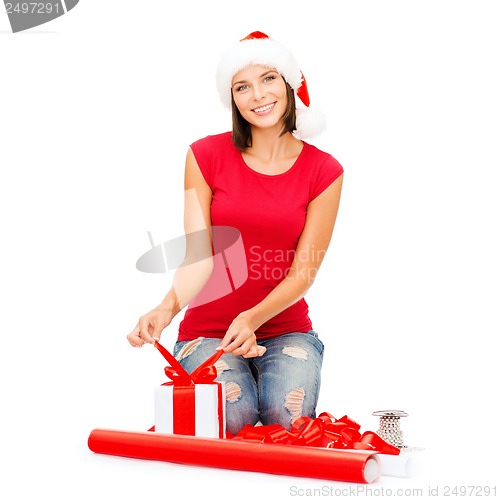 Image of smiling woman in santa helper hat with gift box