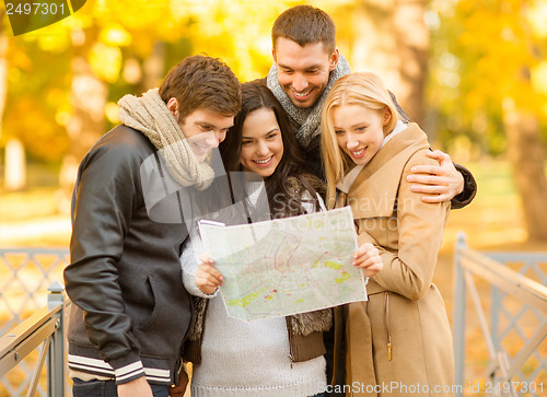 Image of couples with tourist map in autumn park