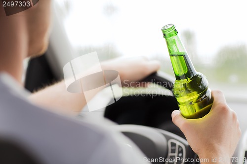 Image of man drinking alcohol while driving the car