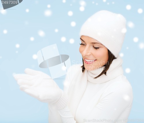 Image of woman in winter clothes with something on palms
