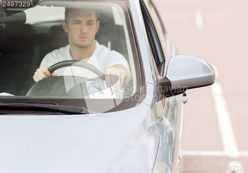 Image of man placing parking clock on car dashboard