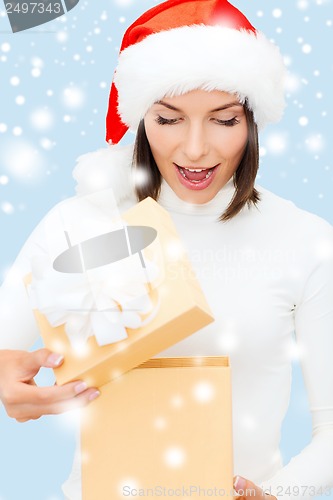 Image of surprised woman in santa helper hat with gift box