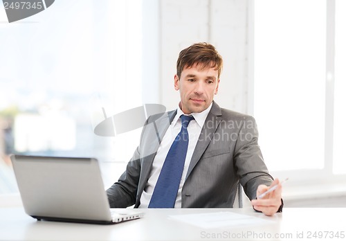 Image of businessman with laptop computer and documents