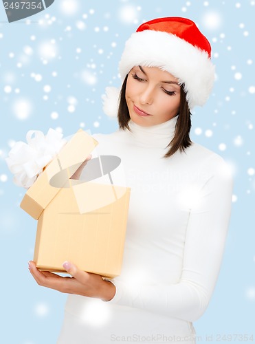 Image of suspicious woman in santa helper hat with gift box