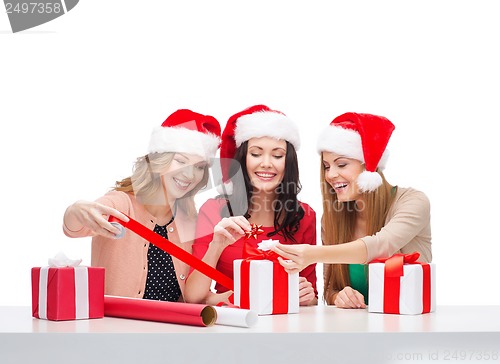 Image of smiling women in santa helper hats with gift boxes