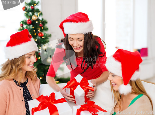 Image of women in santa helper hats with many gift boxes