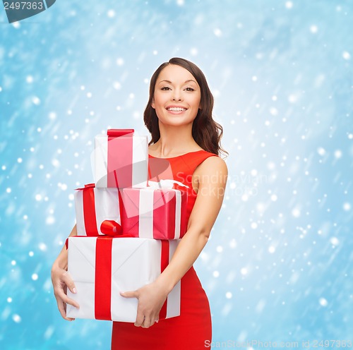 Image of smiling woman in red dress with many gift boxes