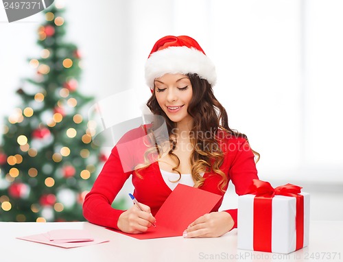 Image of smiling woman in santa helper hat with postcard