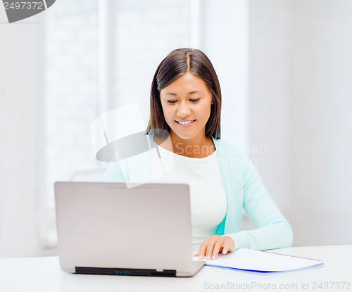 Image of asian businesswoman with laptop and documents