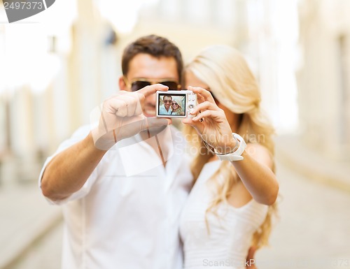 Image of travelling couple taking photo picture with camera