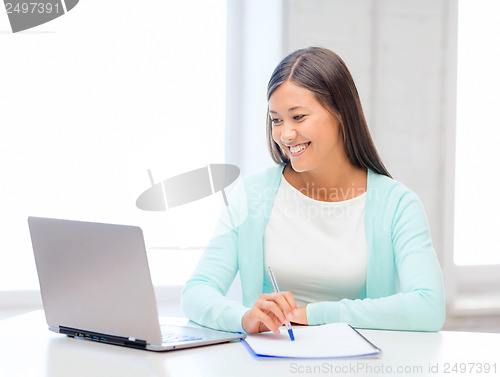 Image of asian businesswoman with laptop and documents